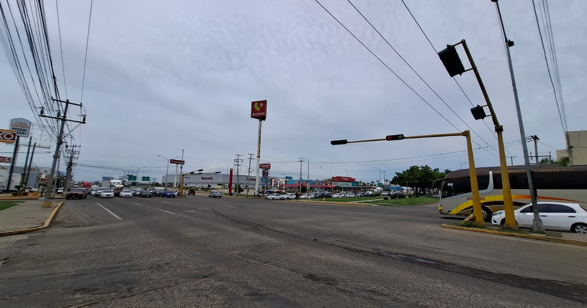 Intersección de calles en Mazatlán con vehículos, señales de tráfico y un letrero de 'Soriana'.