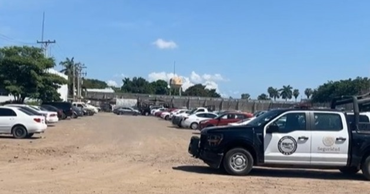 Estacionamiento con auto de seguridad en Culiacán, relacionado con incidente en penal de Aguaruto.