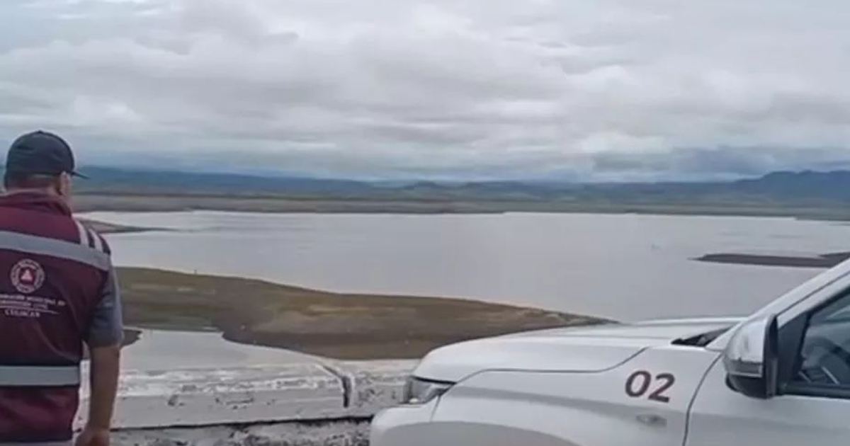 Hombre observando presa en Sinaloa con vehículo blanco y paisaje montañoso
