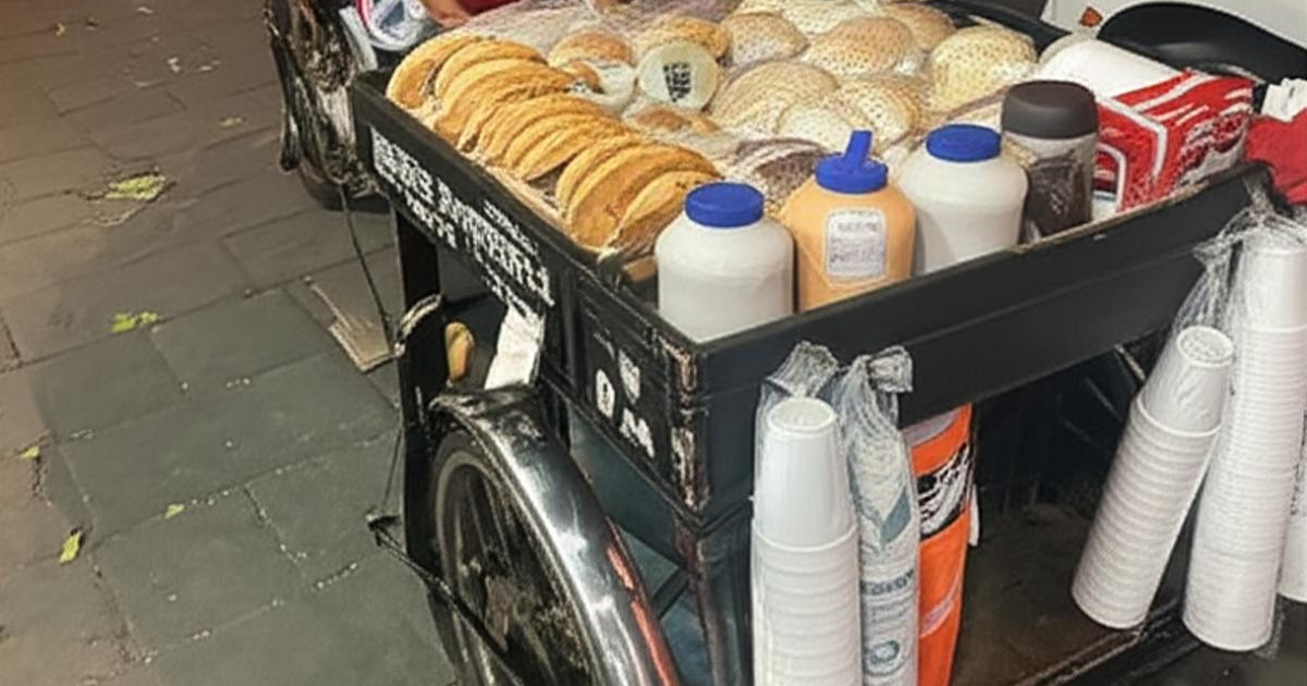 Carrito de comida con panes y bebidas en un entorno urbano