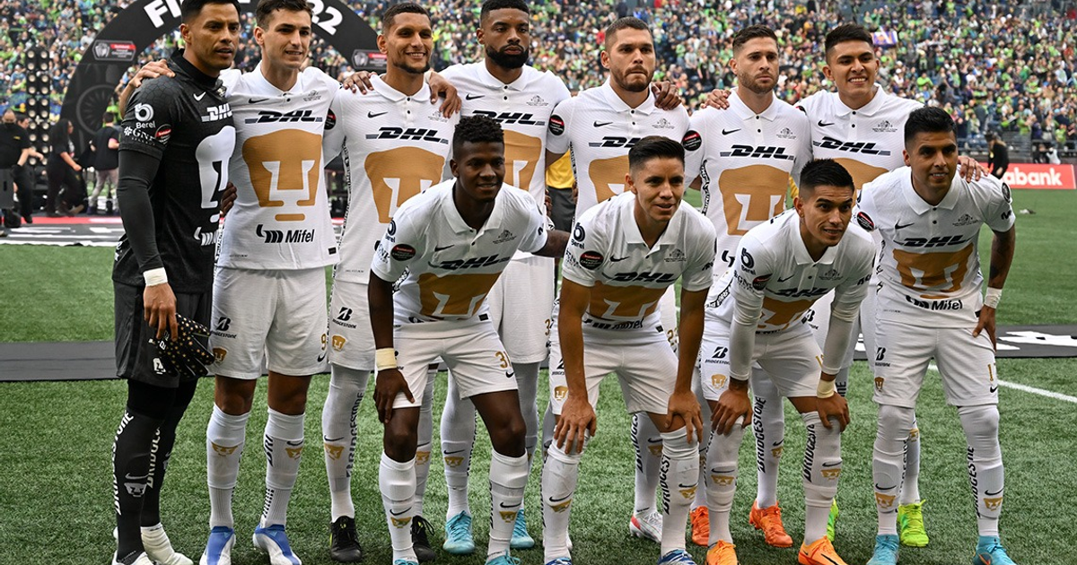 Jugadores de Pumas posando en el campo durante la Leagues Cup, con camisetas blancas y detalles dorados, listos para un partido crucial.