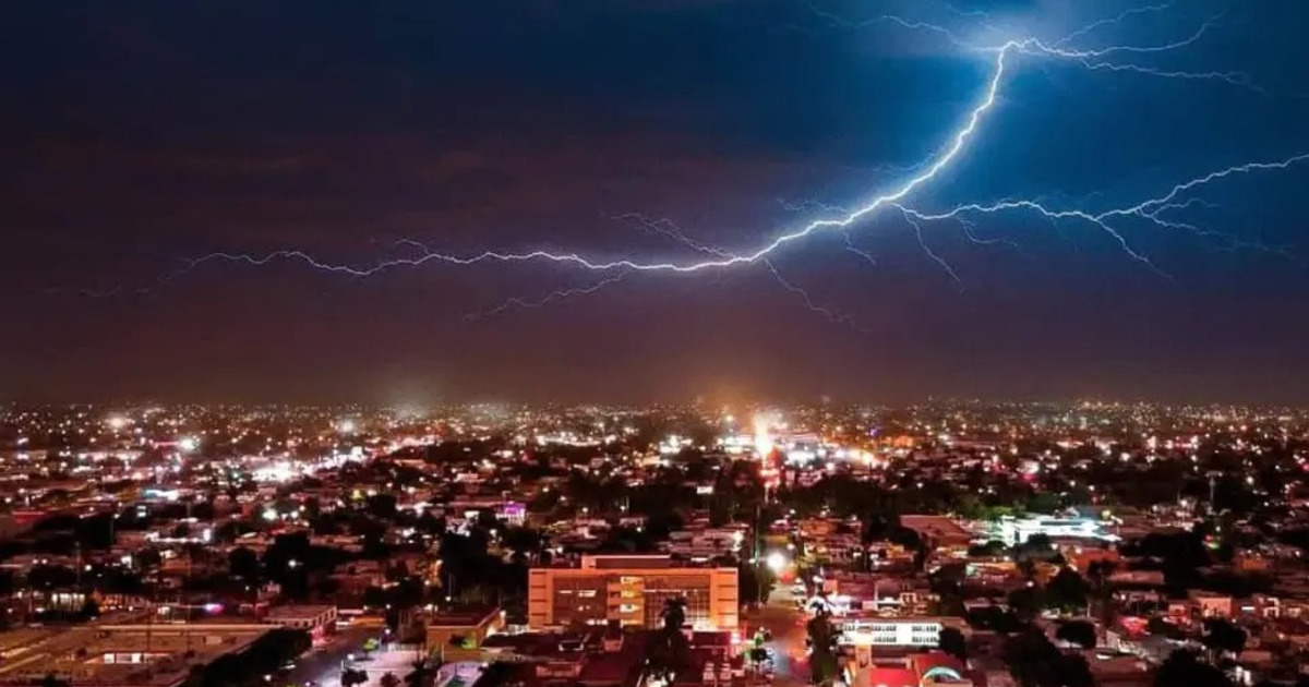 Vista nocturna de Los Mochis con rayos iluminando el cielo durante una tormenta eléctrica.