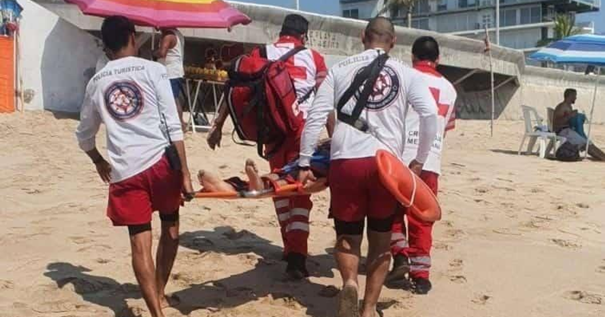 Rescatistas en la playa de Mazatlán llevando a una persona en camilla durante un operativo de salvamento.