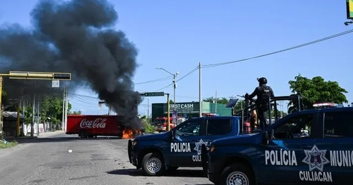 Camión de Coca-Cola en llamas con policía presente en Culiacán