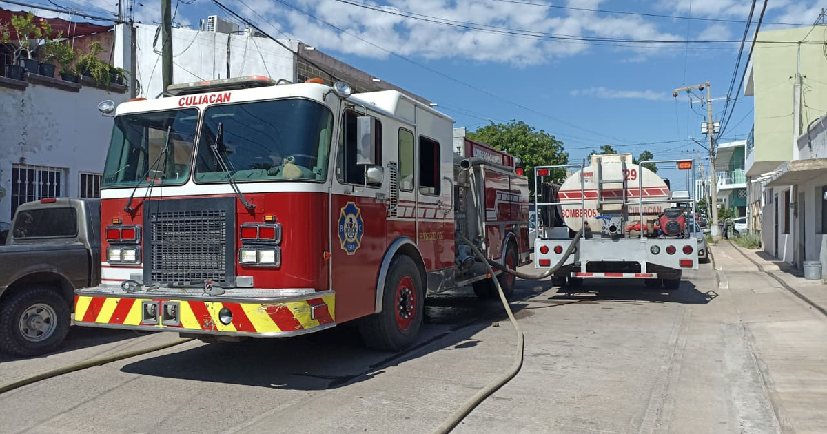 Camión de bomberos de Culiacán estacionado en una calle urbana, junto a un tanque de agua.