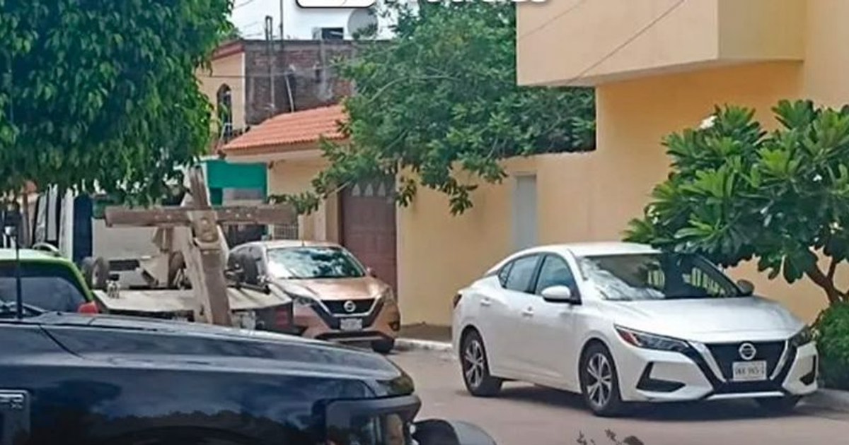 Calle en Culiacán con vehículos estacionados, incluyendo un Nissan Sentra blanco.