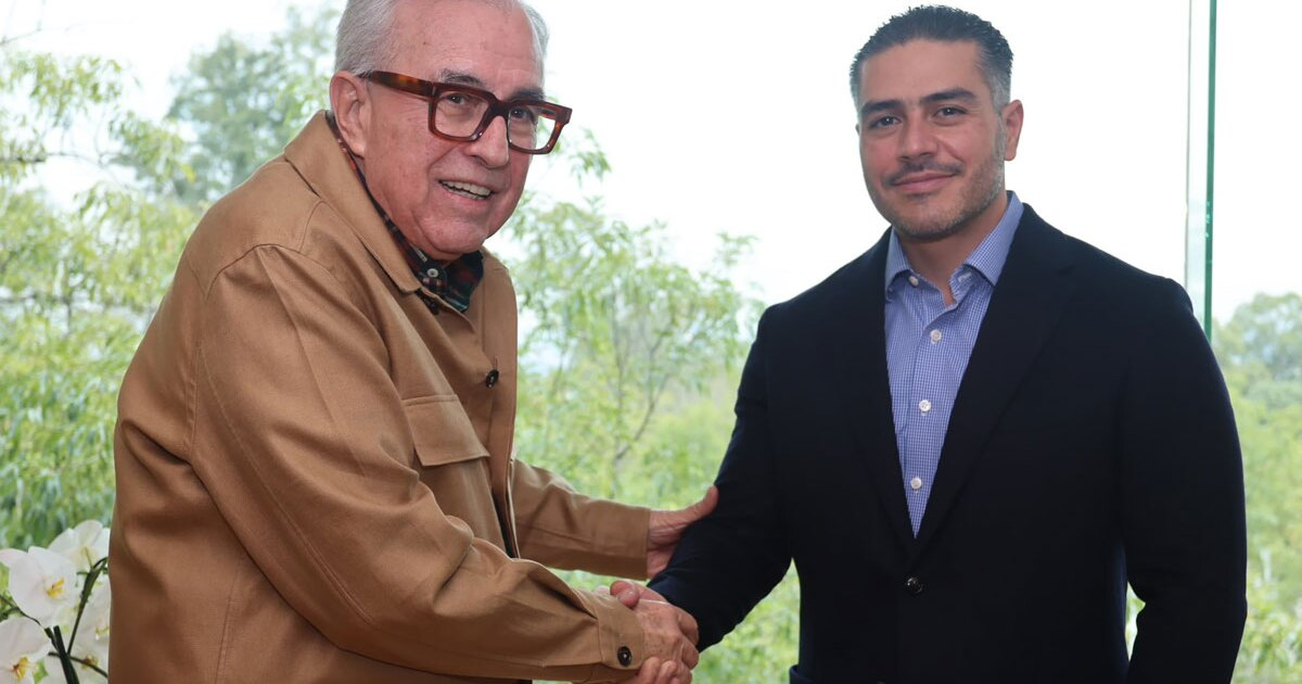 Dos hombres dándose la mano en un entorno natural, simbolizando un acuerdo o saludo.