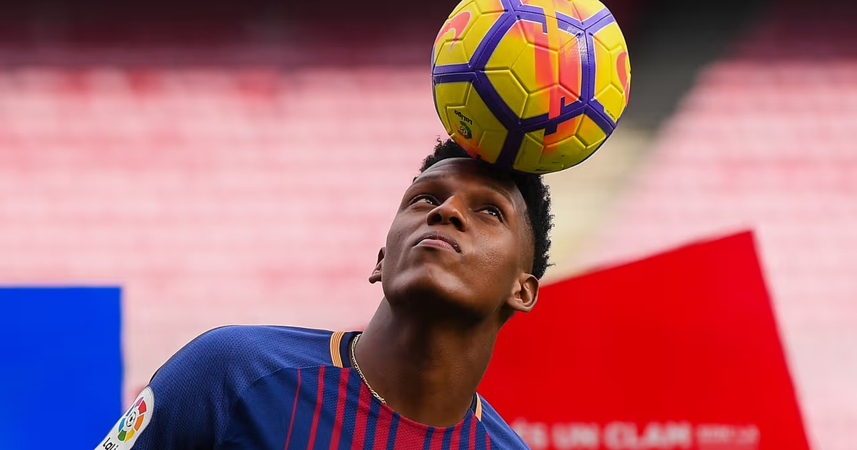 Jugador de fútbol equilibrando un balón sobre su cabeza en un estadio