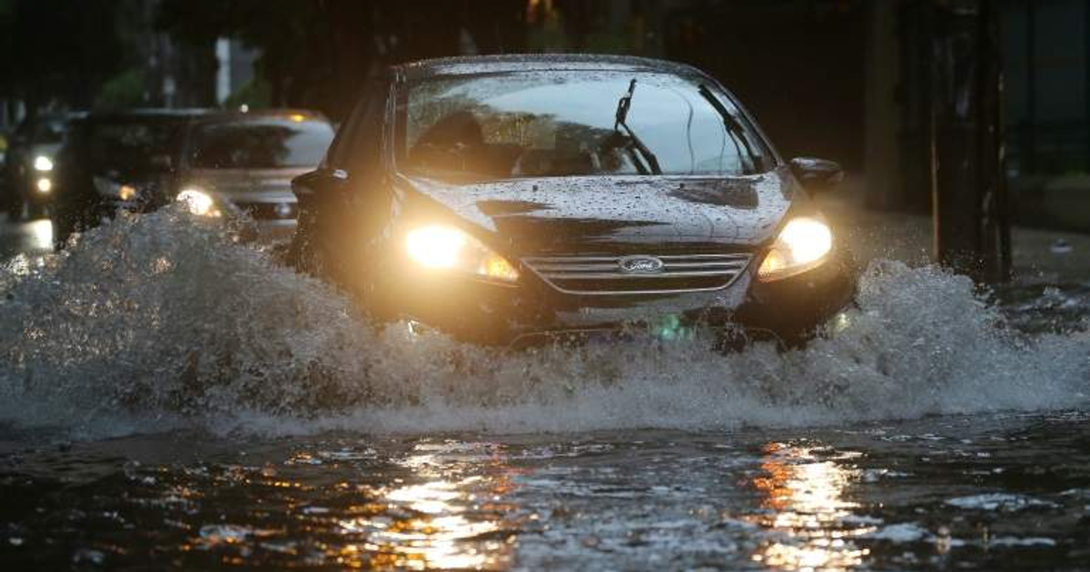 Automóvil negro en calle inundada durante tormenta en Guasave, Sinaloa
