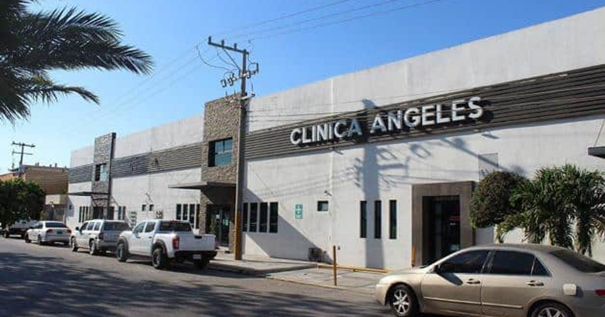 Fachada de la Clínica Ángeles en Los Mochis, Sinaloa, con vehículos estacionados y un cielo despejado.