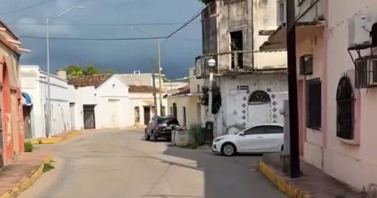 Calle urbana en Escuinapa con edificios y vehículos estacionados durante un apagón masivo.