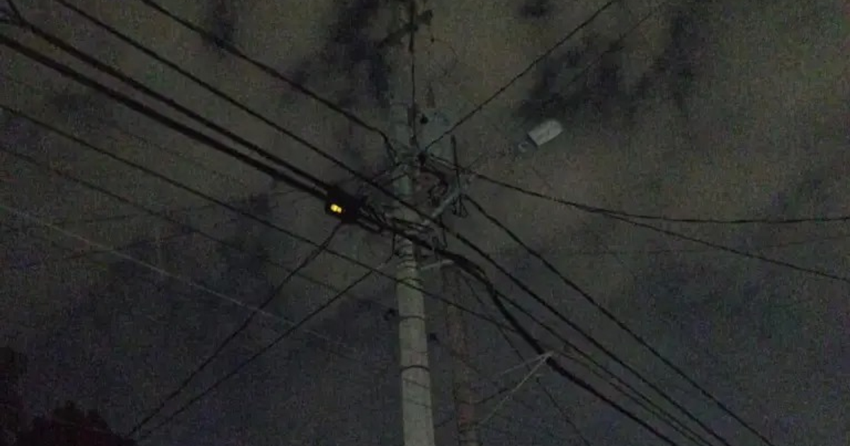 Poste de luz con cables y dispositivo iluminado en Mazatlán durante apagones nocturnos.
