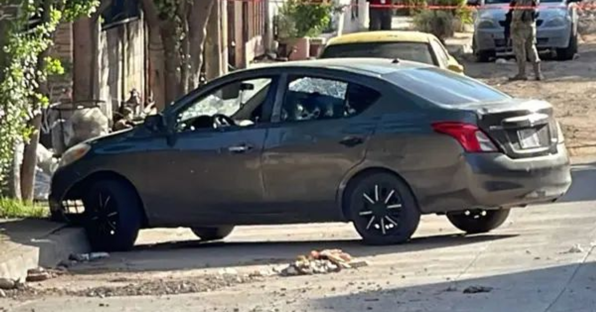 Nissan Versa gris con ventanas rotas y escombros en Culiacán, escena del crimen