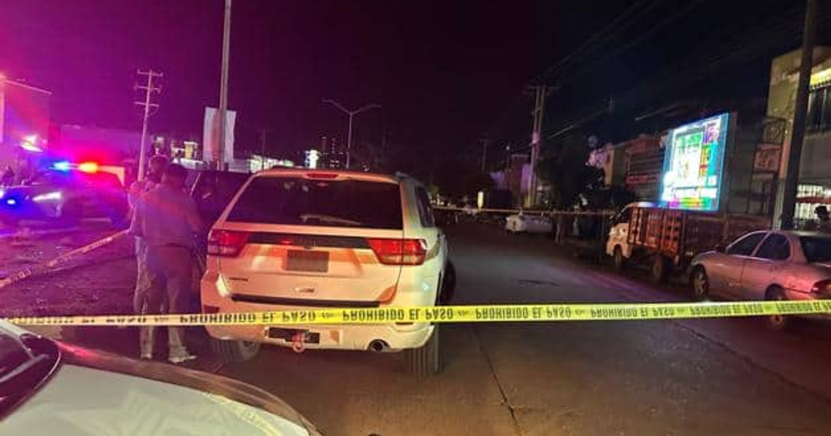 Escena nocturna de accidente en Los Mochis con vehículos de emergencia y cinta amarilla.
