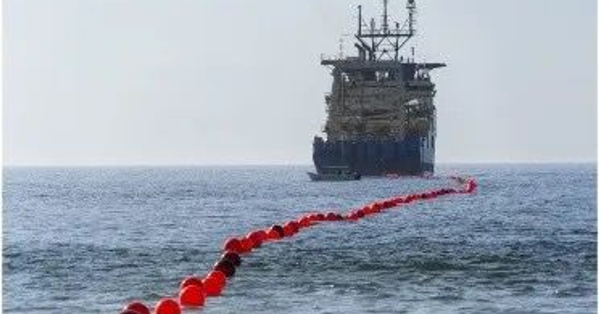 Barco en el mar con boyas rojas, representando el monitoreo del cable submarino TMX5 de TELMEX.