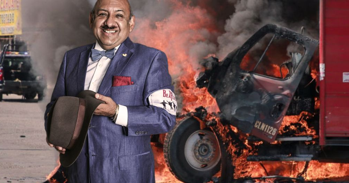 Carlos 'Lord Molécula' Pozos con traje azul y sombrero frente a un vehículo en llamas en Culiacán.