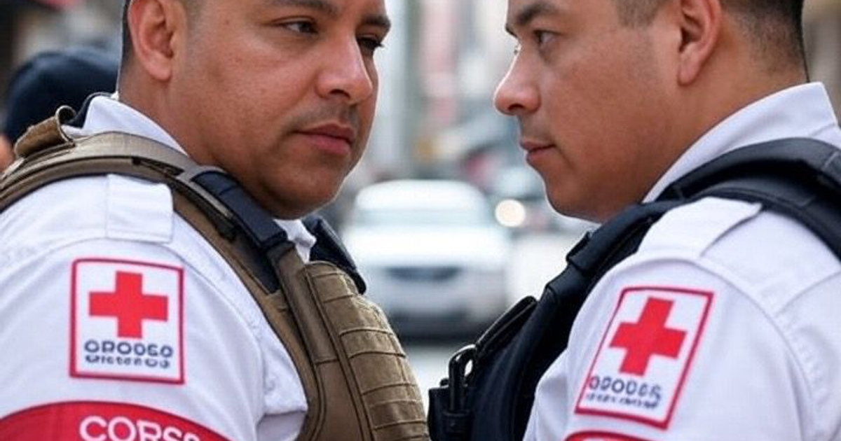 Dos trabajadores de emergencias de GERUM con uniformes de Cruz Roja conversan en un entorno urbano.