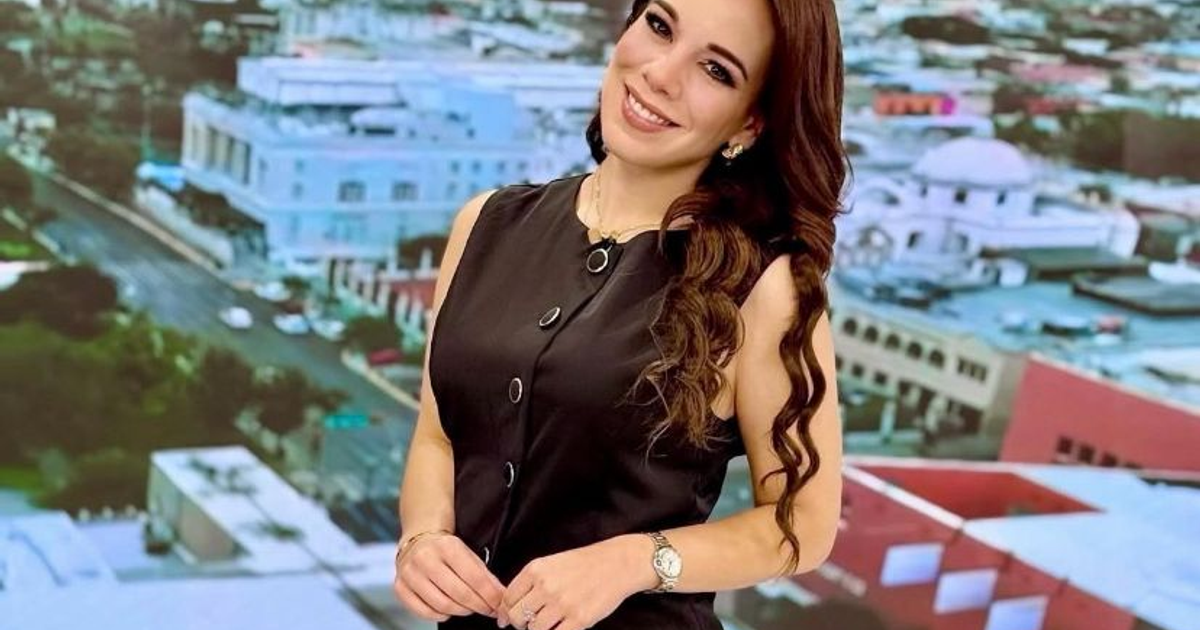 Débora Estrella, conductora de telediario, sonriendo en un estudio con fondo de ciudad.