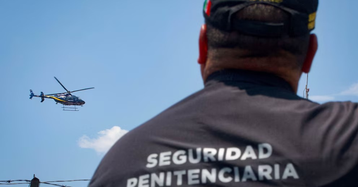 Agente de seguridad penitenciaria con helicóptero en el cielo, operativo en CDMX