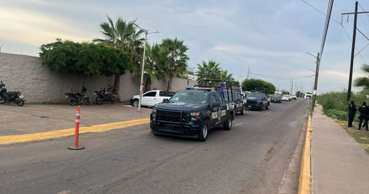 Escena urbana en Villa Juárez con vehículos policiales y personas tras reportes de disparos.