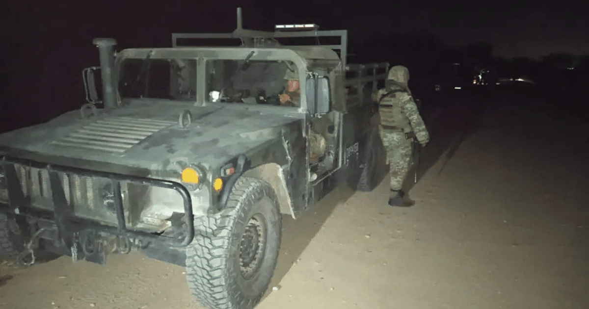 Humvee militar camuflado estacionado en camino de tierra durante la noche en Culiacán, con personal táctico vigilando.