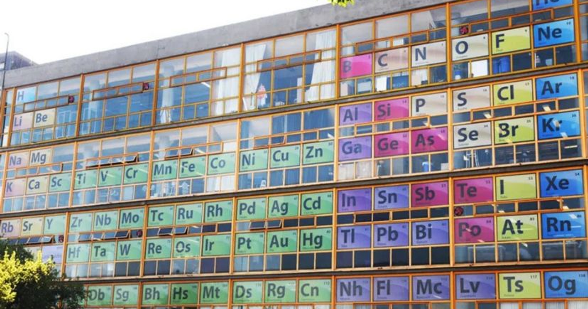 Edificio de la Facultad de Química de la UNAM con ventanas decoradas con símbolos de la tabla periódica.