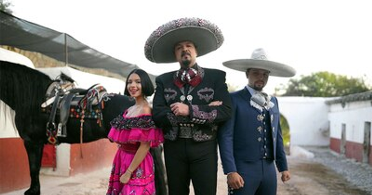 Familia Aguilar en trajes tradicionales mexicanos con caballo y edificación de fondo