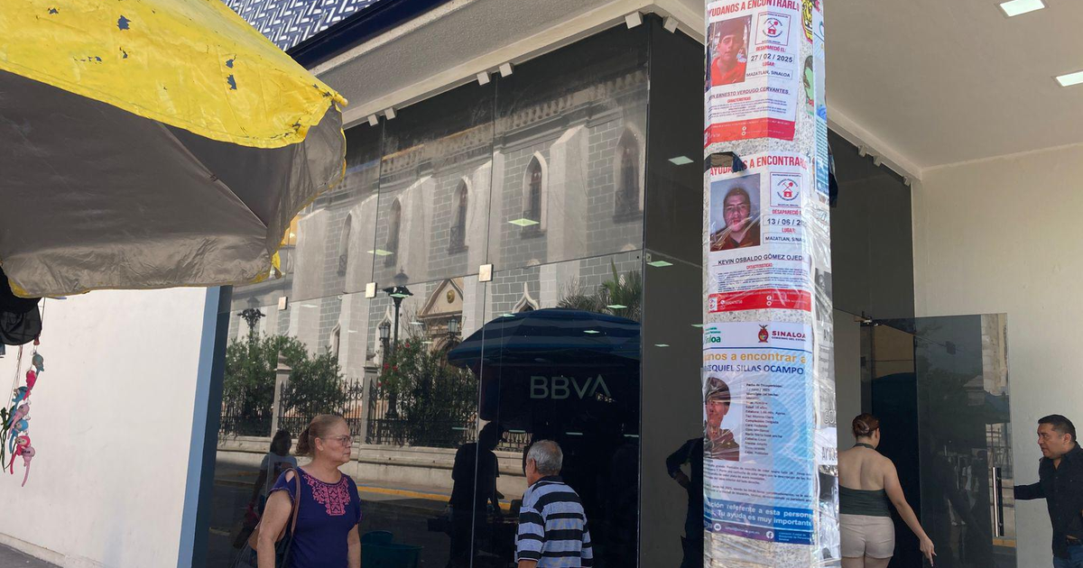 Edificio de BBVA en Mazatlán con carteles de desaparecidos en primer plano