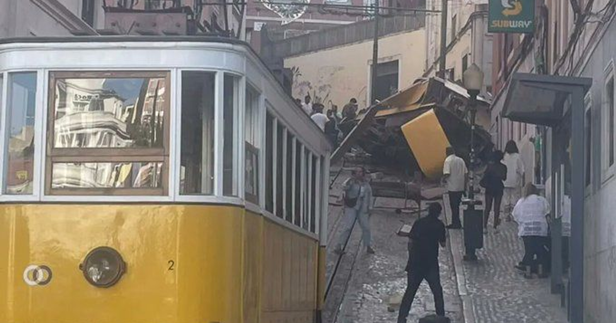 Accidente del funicular de la Glória en Lisboa con tranvía amarillo descarrilado y escombros.