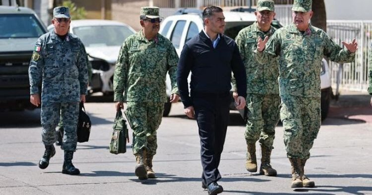 Militares y civiles caminando en Culiacán antes de la reunión del Gabinete de Seguridad