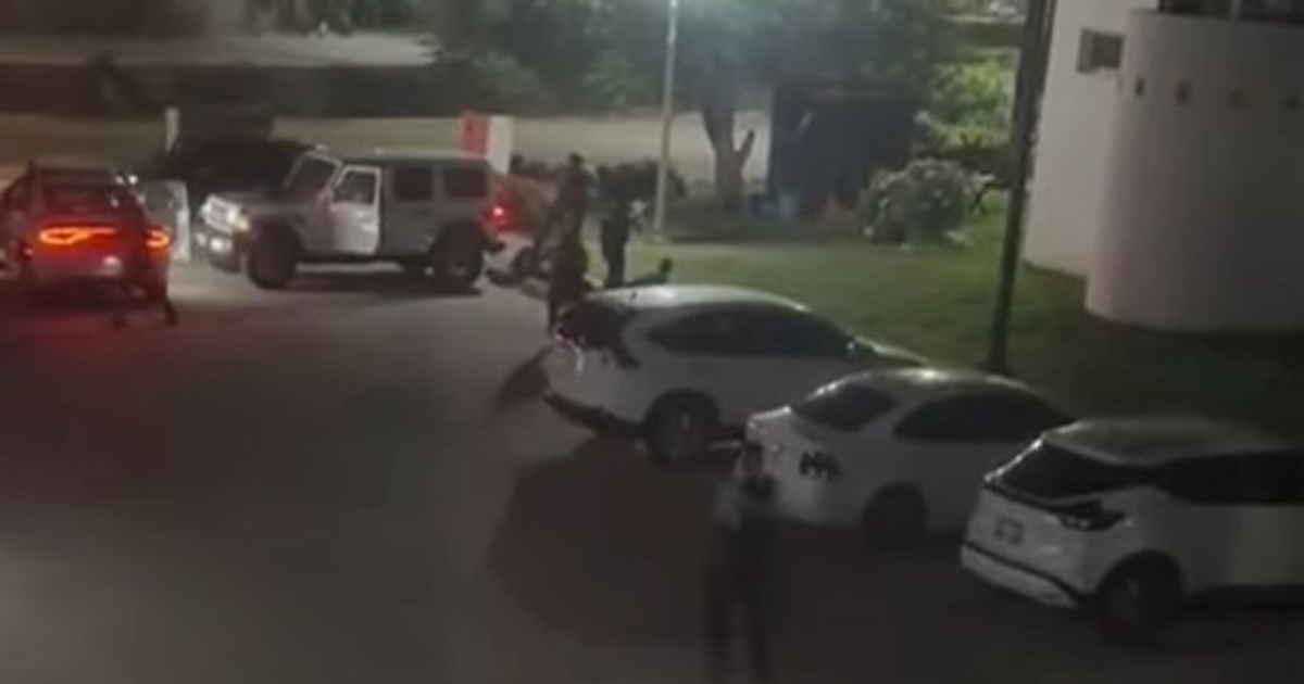 Estacionamiento nocturno en Mazatlán con vehículos y actividad policial