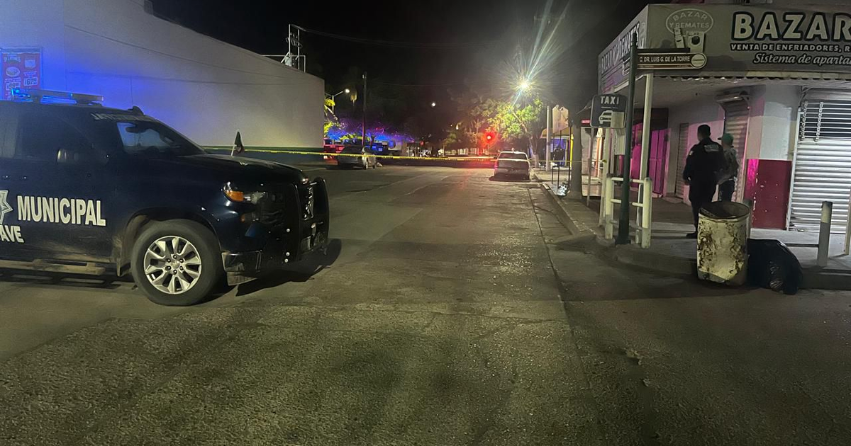 Calle nocturna en Guasave con policía y negocio 'BAZAR'