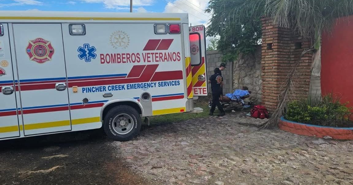 Ambulancia de Bomberos Veteranos y paramédico atendiendo a una persona en camilla en un área residencial