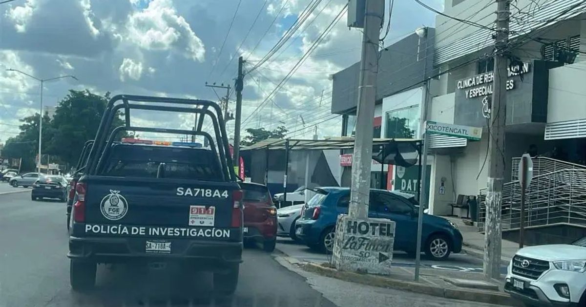 Camioneta de la Policía de Investigación en una calle de Culiacán, Sinaloa, con un edificio de clínica de fondo.