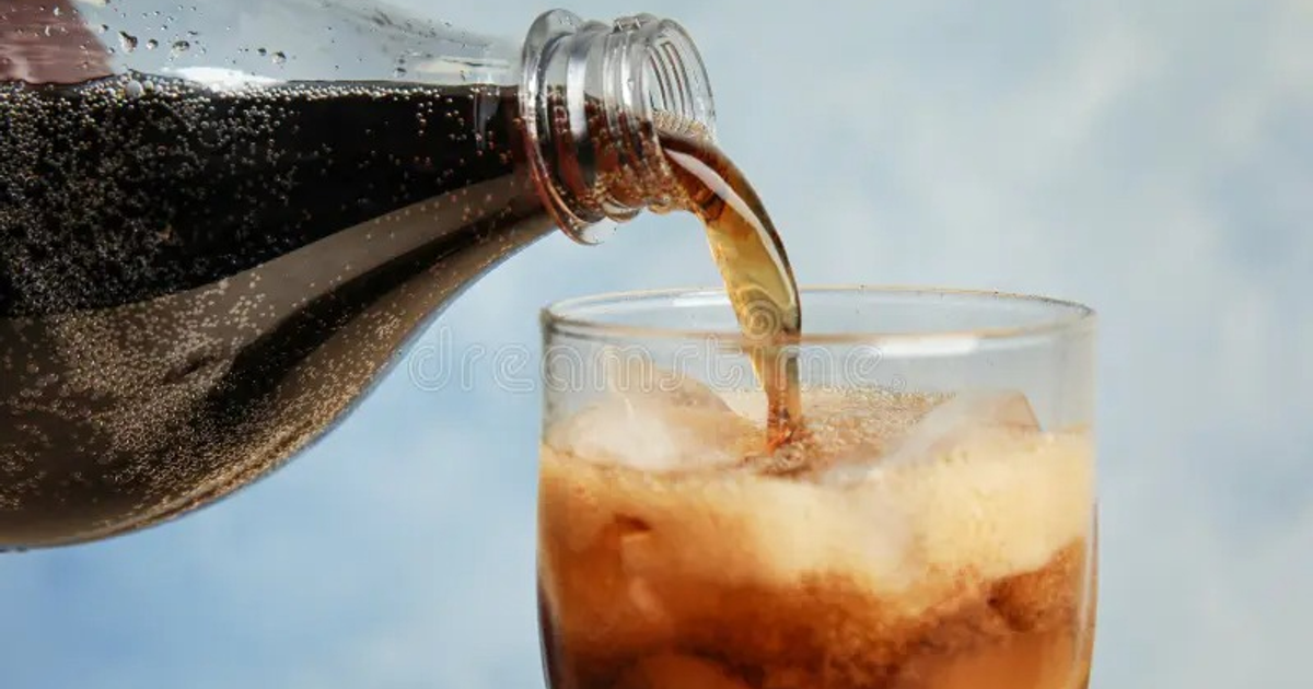 Botella vertiendo bebida carbonatada en vaso con hielo, relacionada con el aumento del IEPS a bebidas azucaradas.