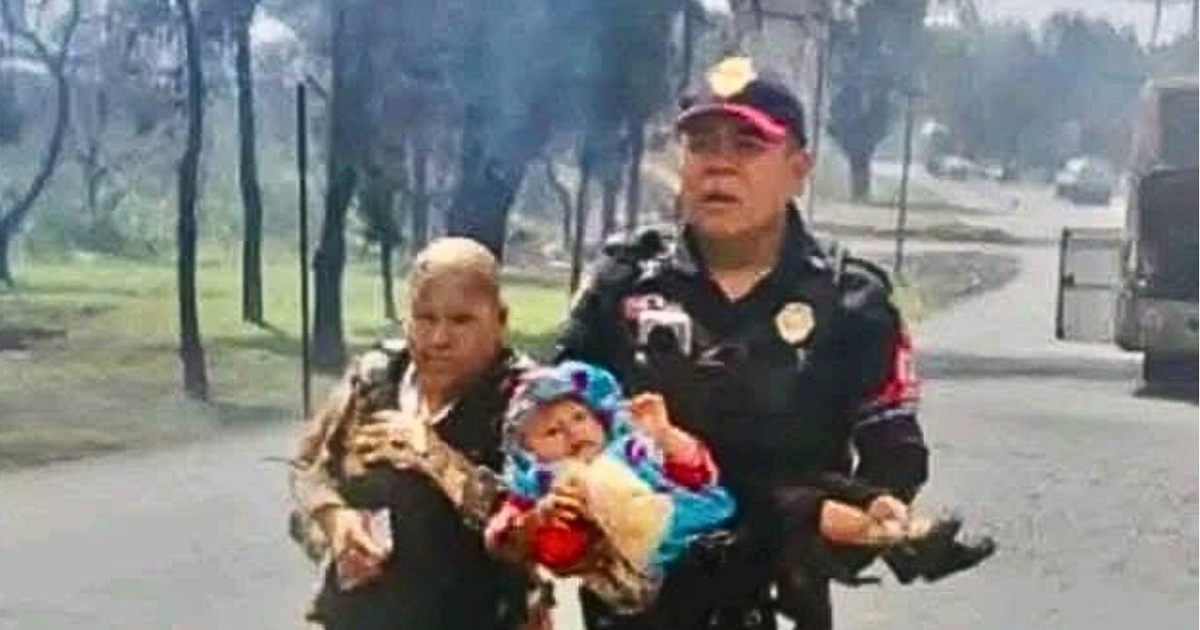 Policía sosteniendo a un bebé en una emergencia en Iztapalapa