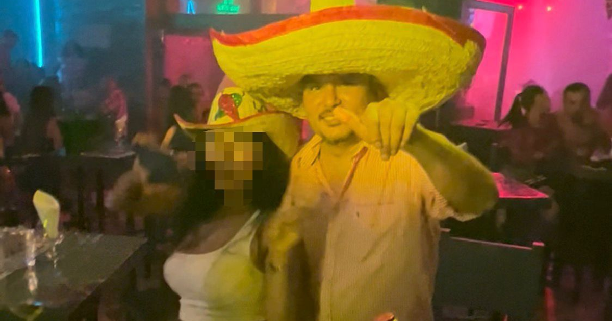 Dos personas con sombreros coloridos en un bar de Mazatlán durante el puente patrio