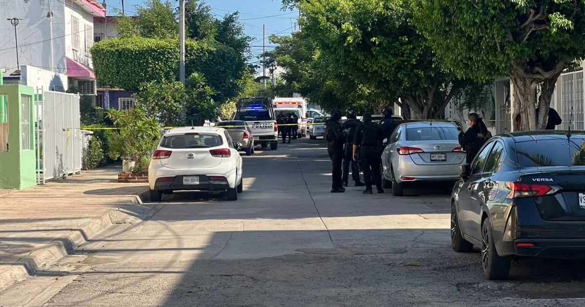 Calle en Mazatlán con vehículos, policía y cinta de emergencia tras ataque armado