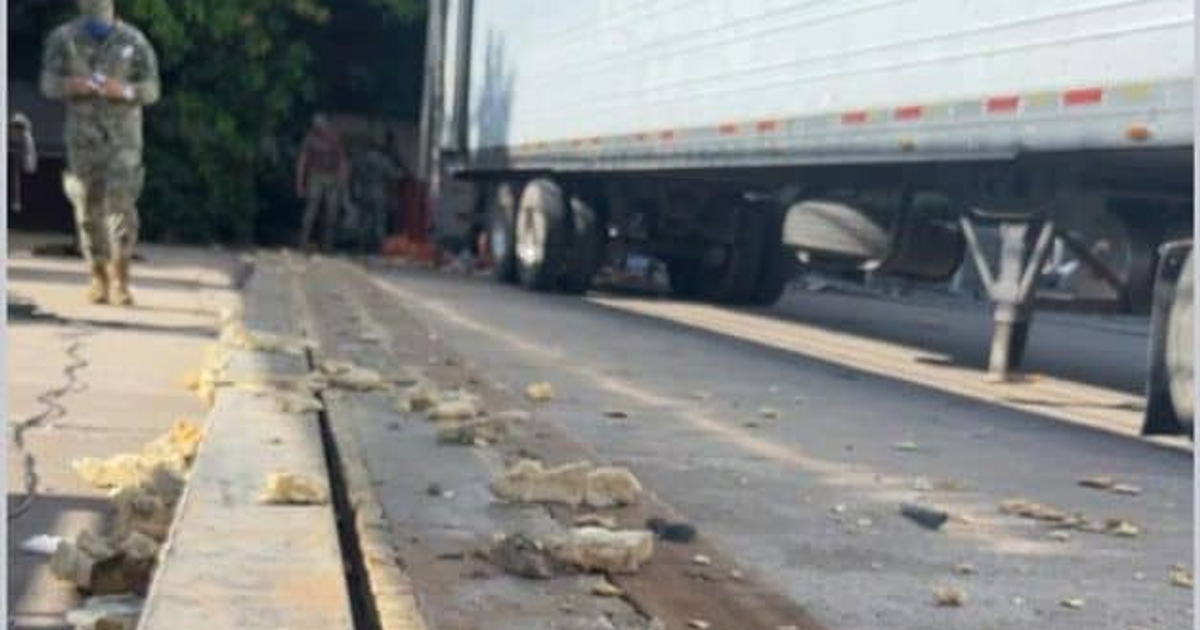 Tractocamión interceptado en Mazatlán con metanfetamina, escena urbana con basura en pavimento y vegetación al fondo.