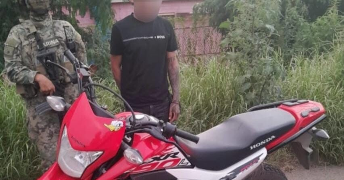 Hombre detenido junto a motocicleta roja y soldado en Mazatlán