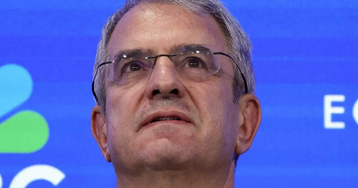 Hombre con gafas mirando hacia arriba, fondo azul, relacionado con el cambio de CEO en Nestlé.