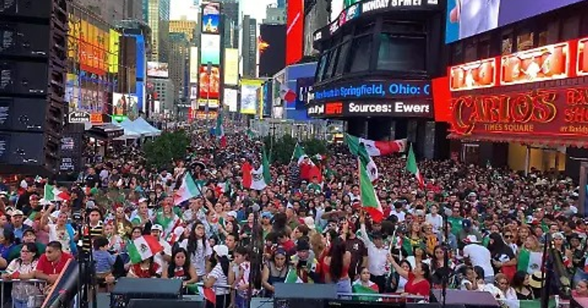 Multitud en Times Square con banderas mexicanas durante una celebración cultural.