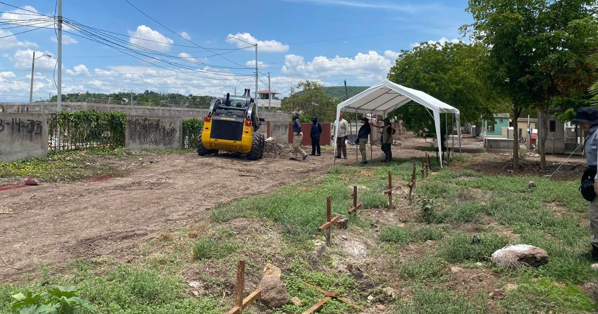 Campamento forense en el Panteón 21 de Marzo con maquinaria y personal trabajando en exhumaciones.