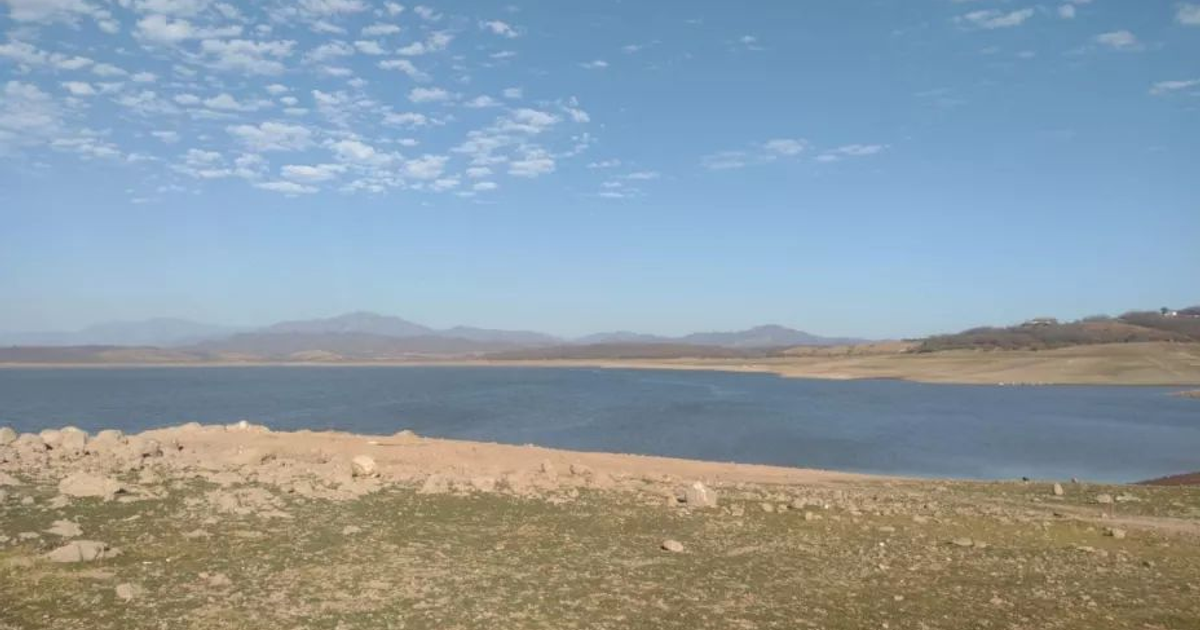 Lago en Sinaloa con montañas al fondo y cielo despejado