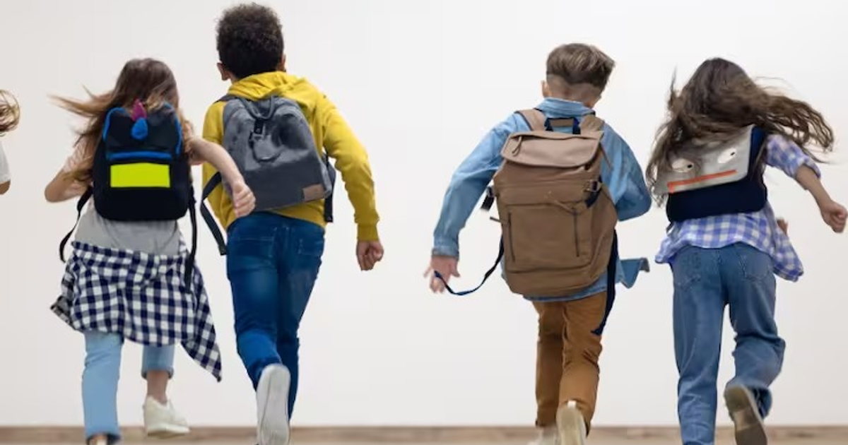 Niños corriendo con mochilas en un ambiente interior, simbolizando el regreso a clases en Sinaloa.
