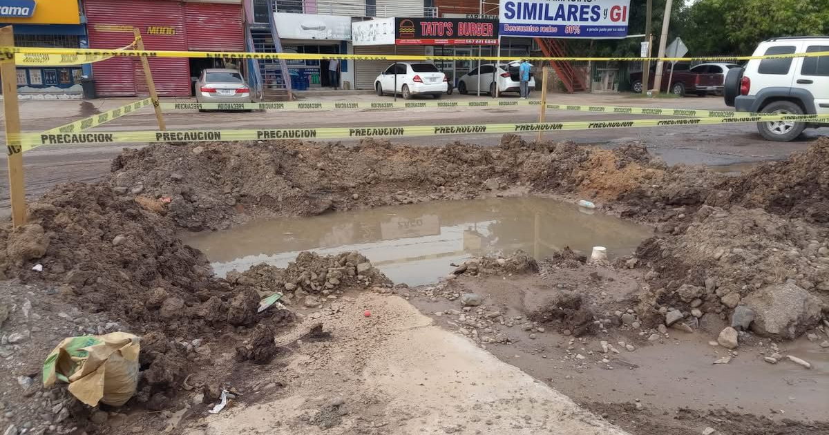 Excavación en Culiacán con charco de agua y cinta de precaución amarilla