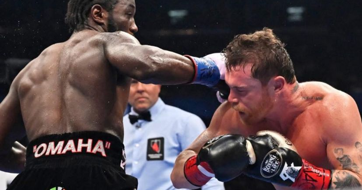 Terence Crawford lanza un golpe a Saúl 'Canelo' Álvarez en el ring, con el árbitro observando en el Allegiant Stadium.