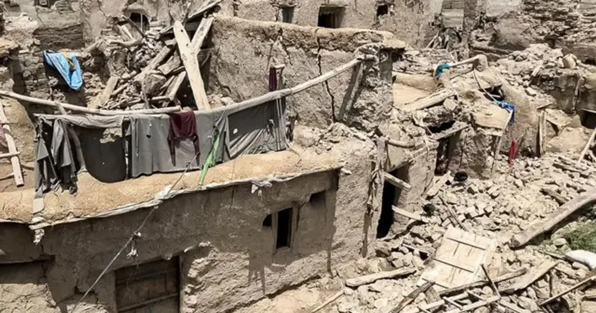 Paisaje urbano en Afganistán devastado por un terremoto, con edificios colapsados y escombros.