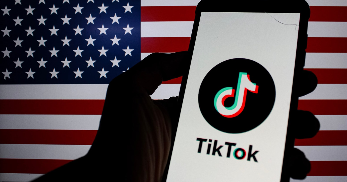 Teléfono móvil con logotipo de TikTok y bandera de EE.UU. de fondo, simbolizando el acuerdo de propiedad estadounidense.