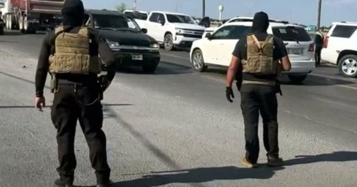 Dos agentes con chalecos tácticos en carretera, vinculados al tiroteo en Reynosa.